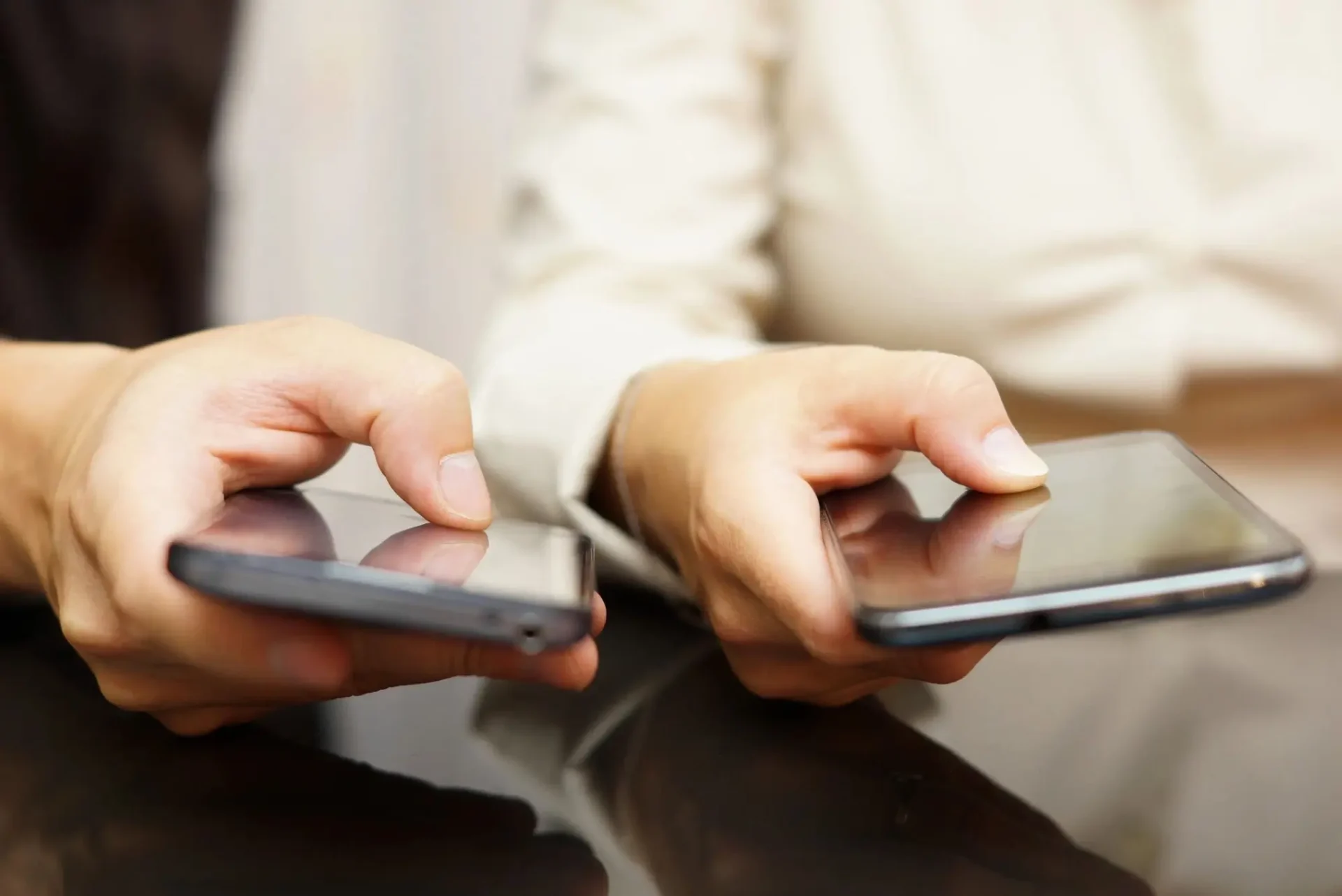Two people are holding their phones in their hands.