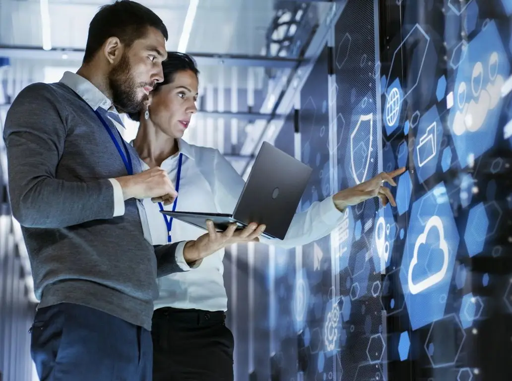 Two people are looking at a computer screen.