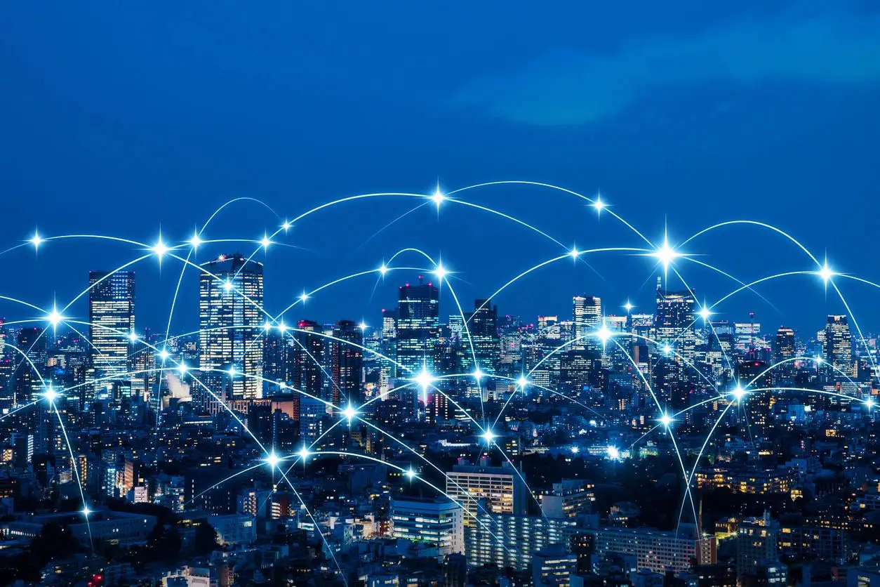 A city skyline with many connected wires in the night sky.